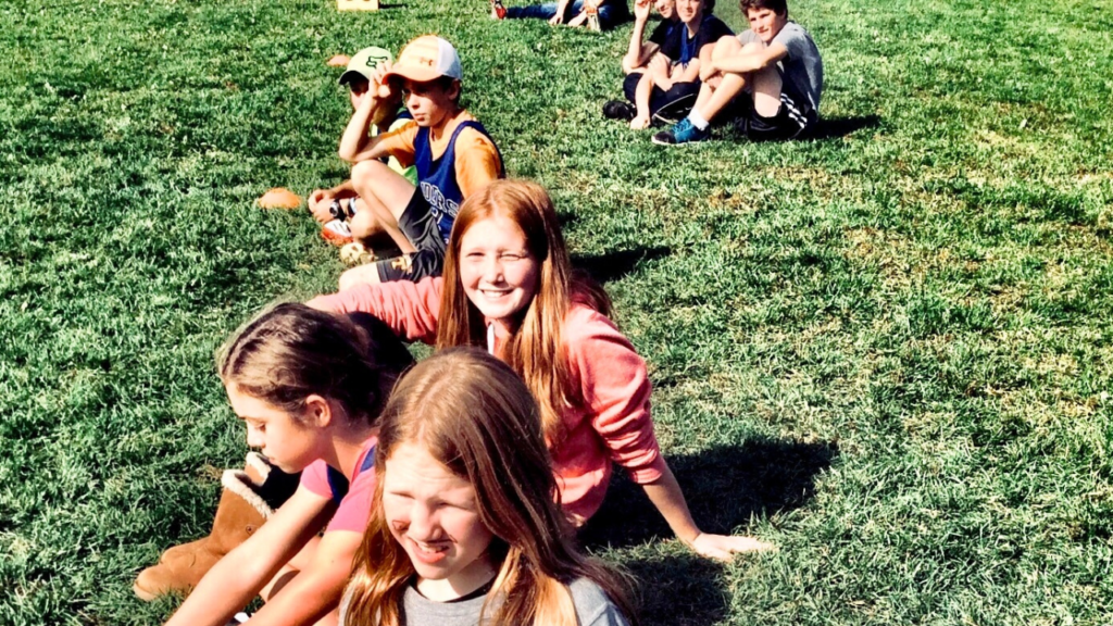 A group of children sitting on the grass